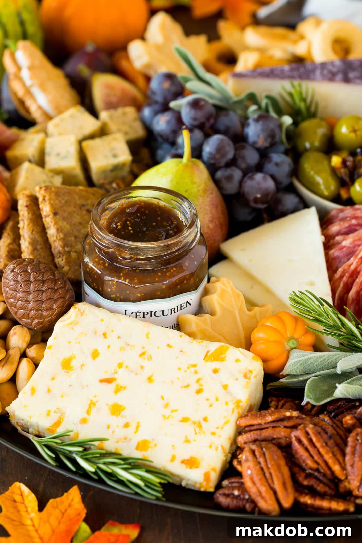A detailed close-up of a meat and cheese board, highlighting the arrangement of nuts, a jar of jam, and other delightful components.