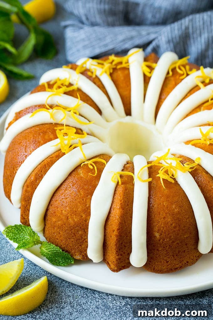 A lemon bundt cake topped with cream cheese frosting and lemon zest, ready to be served.