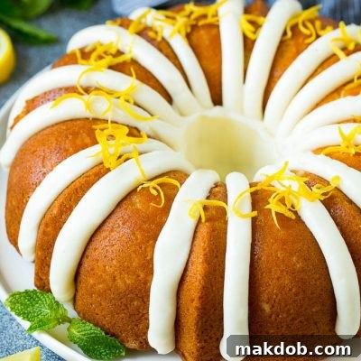 A beautifully frosted lemon bundt cake, garnished with lemon zest.