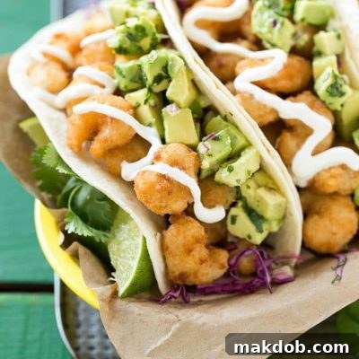 This recipe for fried shrimp tacos is a pile of crispy shrimp that's layered with cilantro lime cabbage slaw and avocado relish then stuffed inside warm flour tortillas. It's a quick and easy meal that tastes like it came from a restaurant! #ShrimpItUp ad