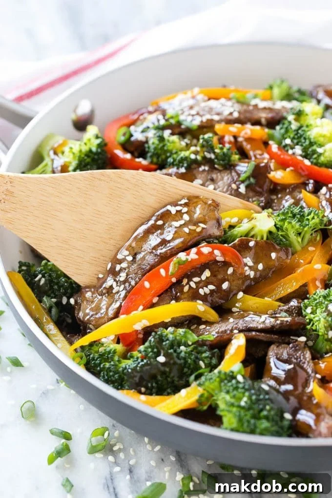 Teriyaki beef stir fry with colorful peppers and broccoli in a large skillet, ready to be served.