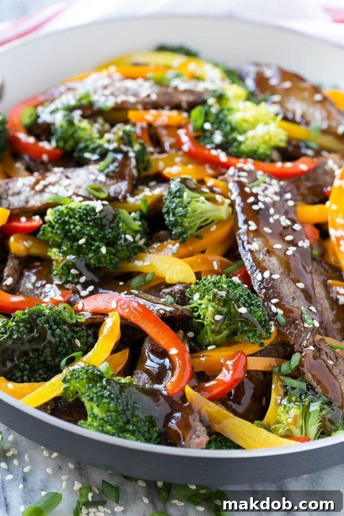Teriyaki beef stir fry plated, showcasing sliced beef, homemade sauce, fresh vegetables, and a sprinkle of sesame seeds.