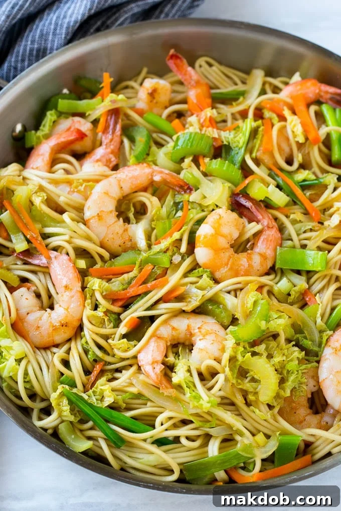 A vibrant pan of Shrimp Chow Mein noodles featuring succulent shrimp and colorful stir-fried vegetables.