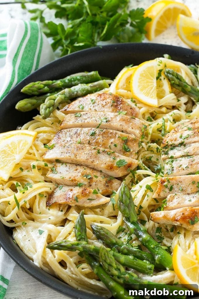Delectable Lemon Asparagus Pasta with Grilled Chicken Lemon asparagus pasta in a creamy sauce topped with grilled chicken, garnished with fresh parsley.