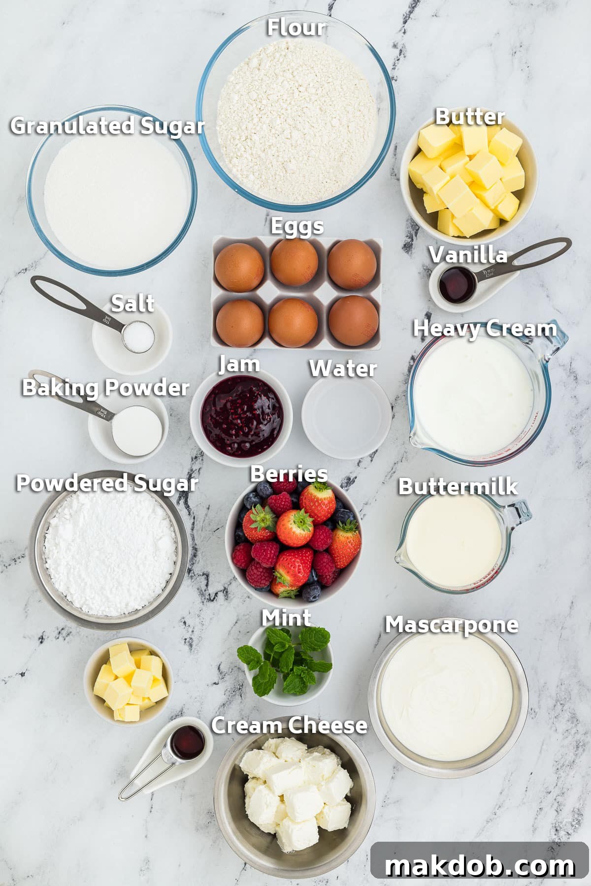 A vibrant display of ingredients for Berry Chantilly Cake, including fresh strawberries, blueberries, blackberries, and raspberries, alongside baking essentials like flour, sugar, butter, eggs, and dairy products like heavy cream, mascarpone, and cream cheese.