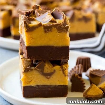 Irresistible Chocolate Peanut Butter Fudge 2 Stacked pieces of chocolate peanut butter fudge on a plate.