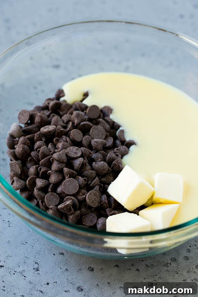 Ingredients for the Chocolate Fudge Layer A mixing bowl filled with semisweet chocolate chips, condensed milk, and butter, ready to be melted for the chocolate fudge layer.