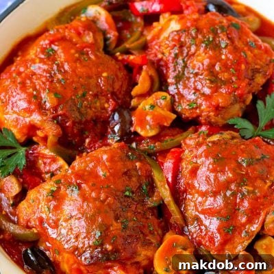 Chicken cacciatore with chicken thighs, peppers, olives and mushrooms in tomato sauce.