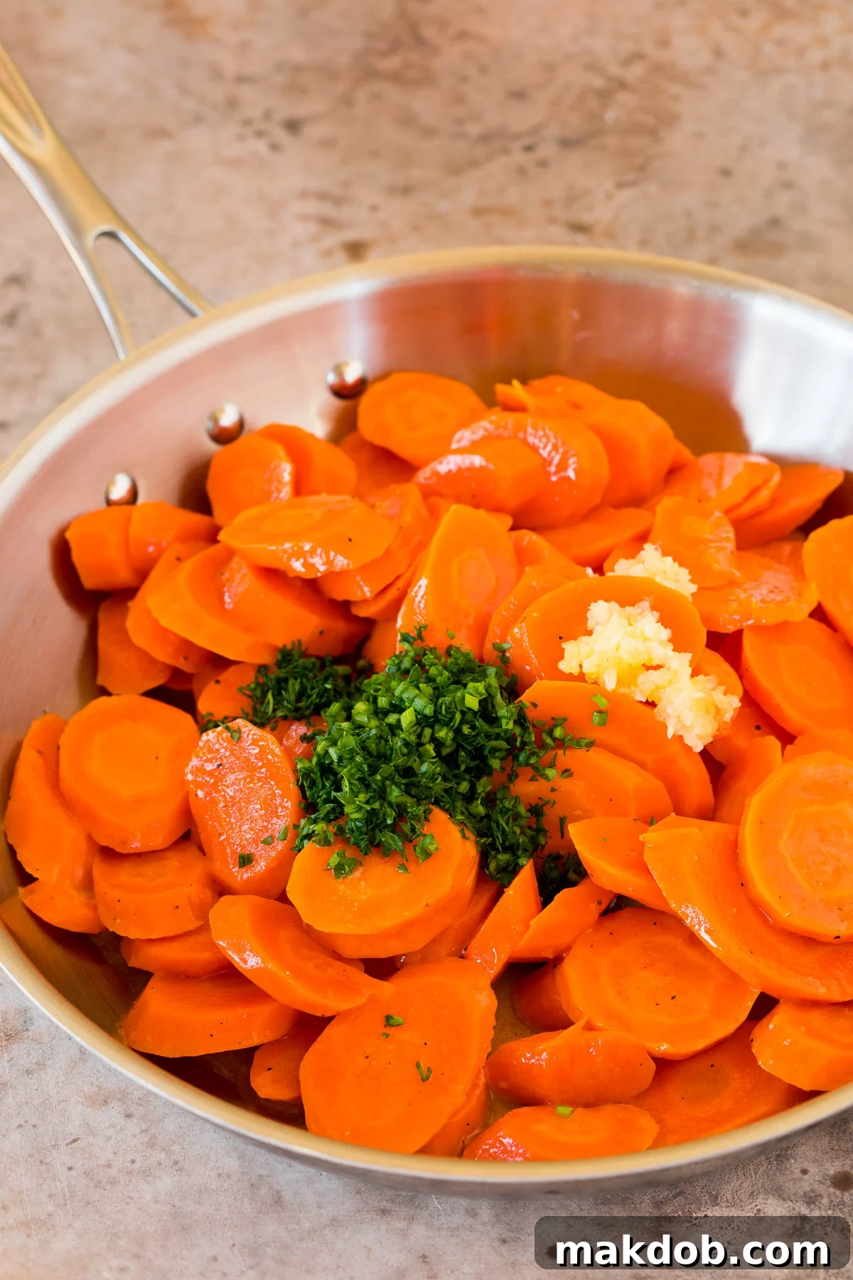 Carrots in a pan with garlic and herbs.