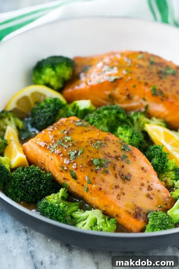 A pan of honey mustard salmon fillets surrounded by broccoli florets.