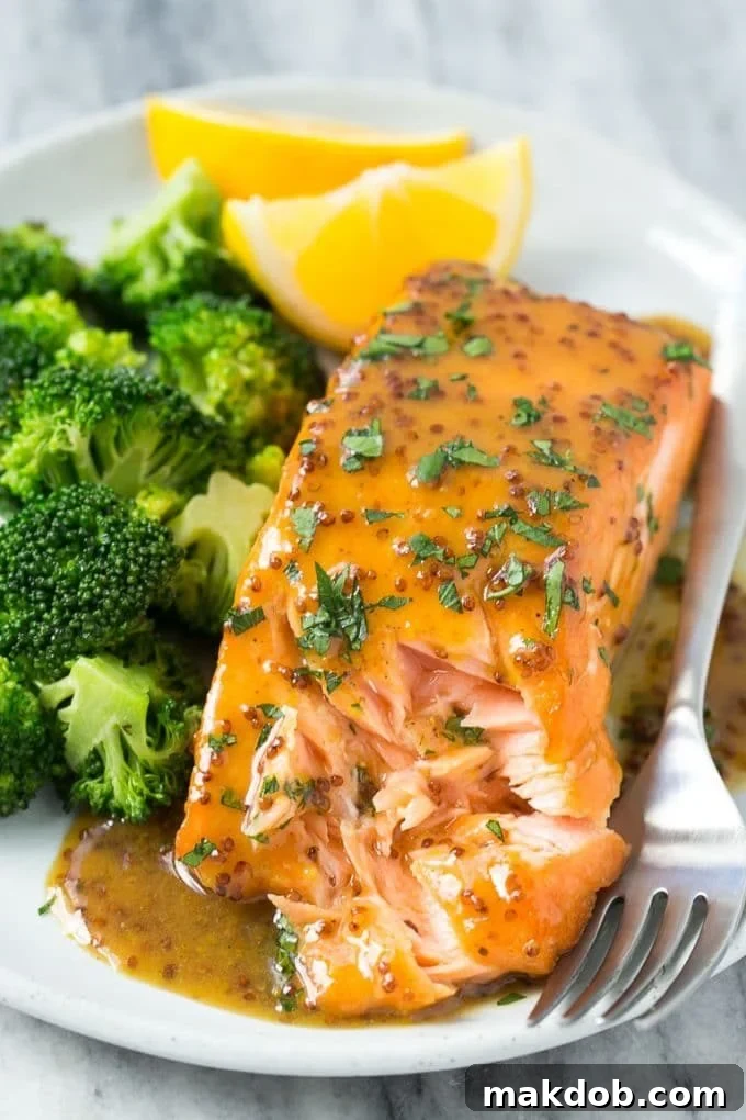 A plate with a honey mustard salmon fillet and cooked broccoli.