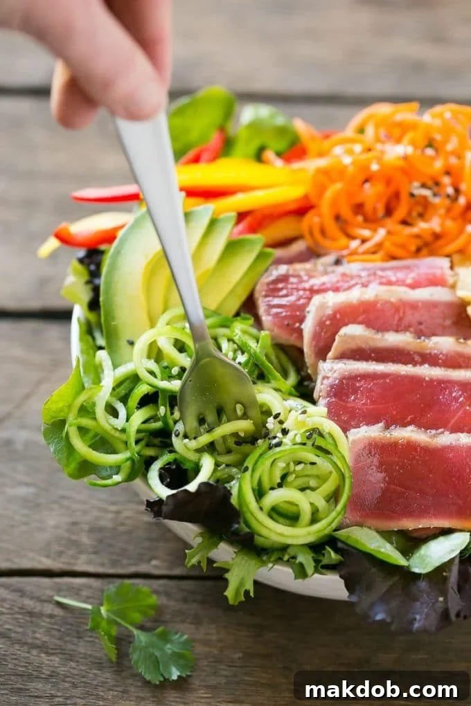 Seared Ahi Tuna Salad with Zesty Sesame Ginger Vinaigrette 3 Seared ahi tuna salad over a bed of greens with bell peppers, wonton strips and cucumber.