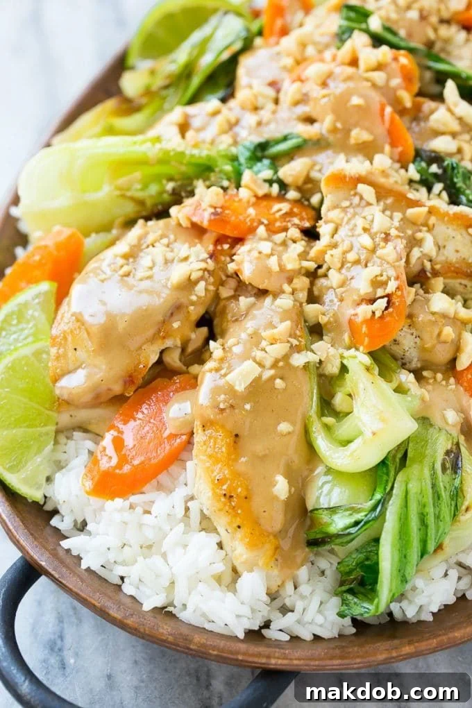 Delicious Thai Peanut Chicken with Crushed Peanuts A platter brimming with Thai peanut chicken, glistening with homemade peanut sauce and topped with a generous sprinkle of crushed peanuts, ready to be enjoyed.