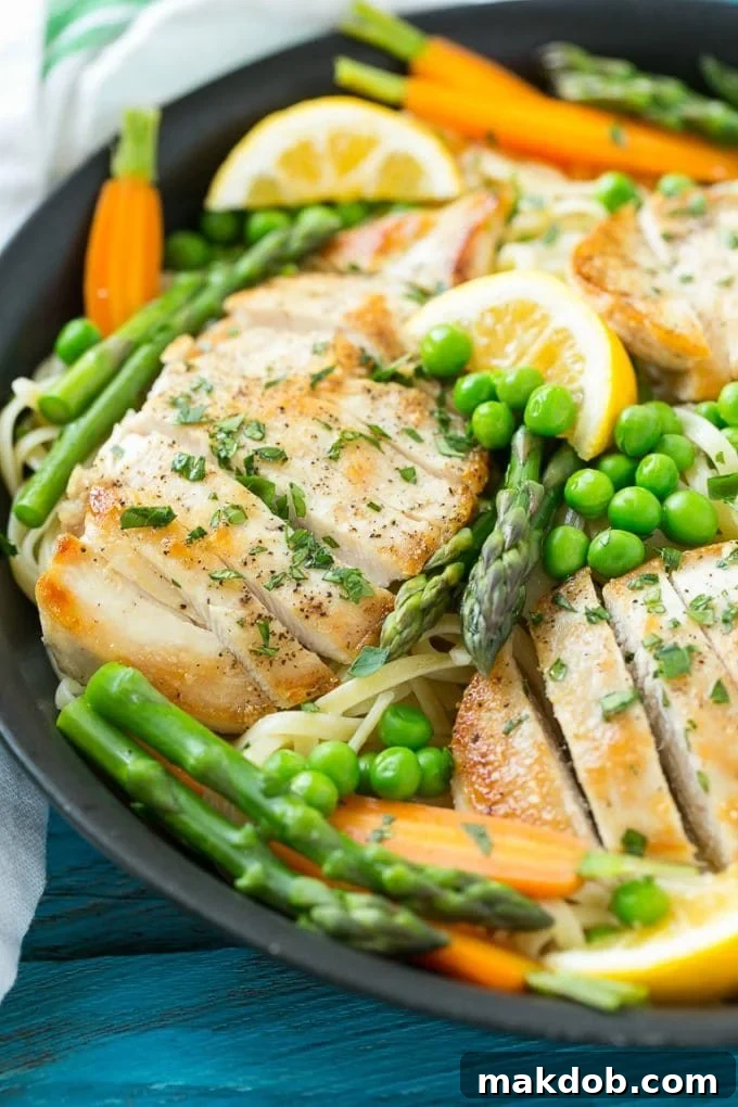 Chicken Primavera Recipe | Chicken Pasta | Vegetable Pasta #chicken #pasta #asparagus #carrots #peas #spring #dinner #dinneratthezoo A skillet of chicken primavera pasta with peas, carrots and asparagus, ready to be served.
