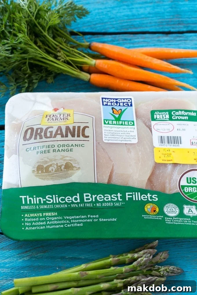 Chicken Primavera Recipe | Chicken Pasta | Vegetable Pasta #chicken #pasta #asparagus #carrots #peas #spring #dinner #dinneratthezoo A package of organic chicken breasts next to a bunch of fresh carrots, highlighting quality ingredients.