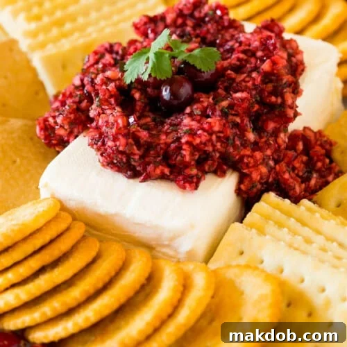 Cranberry jalapeno dip served on a block of cream cheese with crackers.