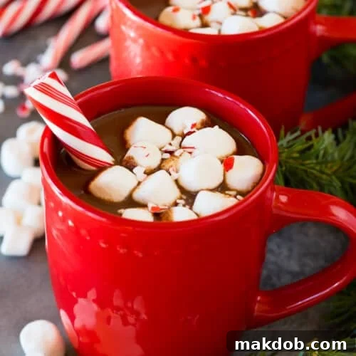 Peppermint Cocoa Bliss 7 Mugs of peppermint hot chocolate topped with marshmallows and a peppermint stick.