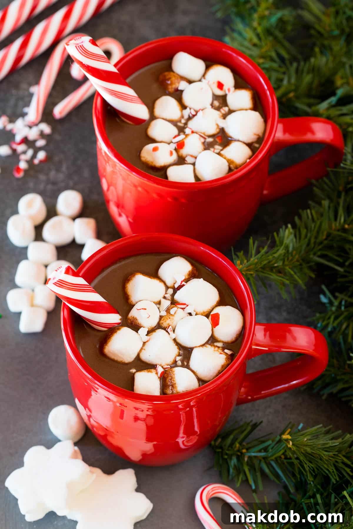 Peppermint Cocoa Bliss 6 Two red mugs full of peppermint hot chocolate topped with marshmallows.