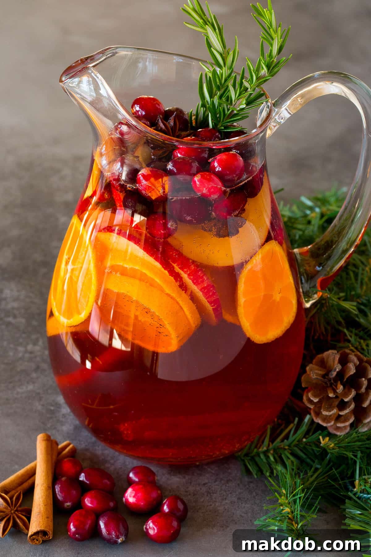 Jolly Christmas Sangria 6 A pitcher of Christmas sangria filled with sliced fruit and cranberries.