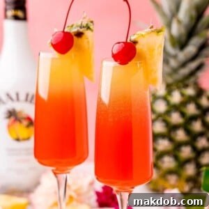 An image of two vibrant Hawaiian Mimosas, garnished with pineapple slices, exuding a tropical and festive atmosphere.