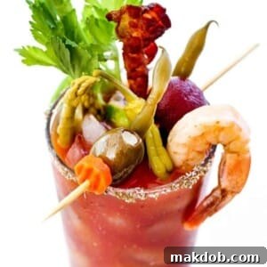 An image of a classic Bloody Mary cocktail, garnished with a celery stalk, lemon wedge, and olives.