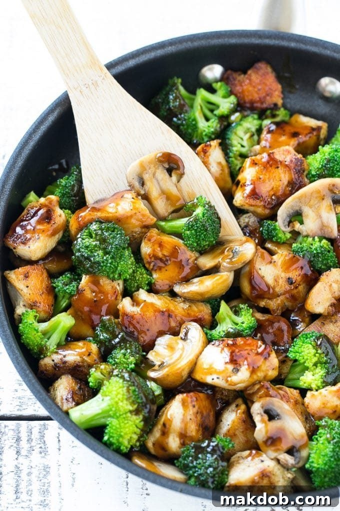 Chicken and Broccoli Stir Fry Recipe | Chicken Stir Fry | Healthy Chicken Recipe | Chicken and Broccoli | Chinese Food Chicken and broccoli stir fry with mushrooms in a skillet with a spatula.