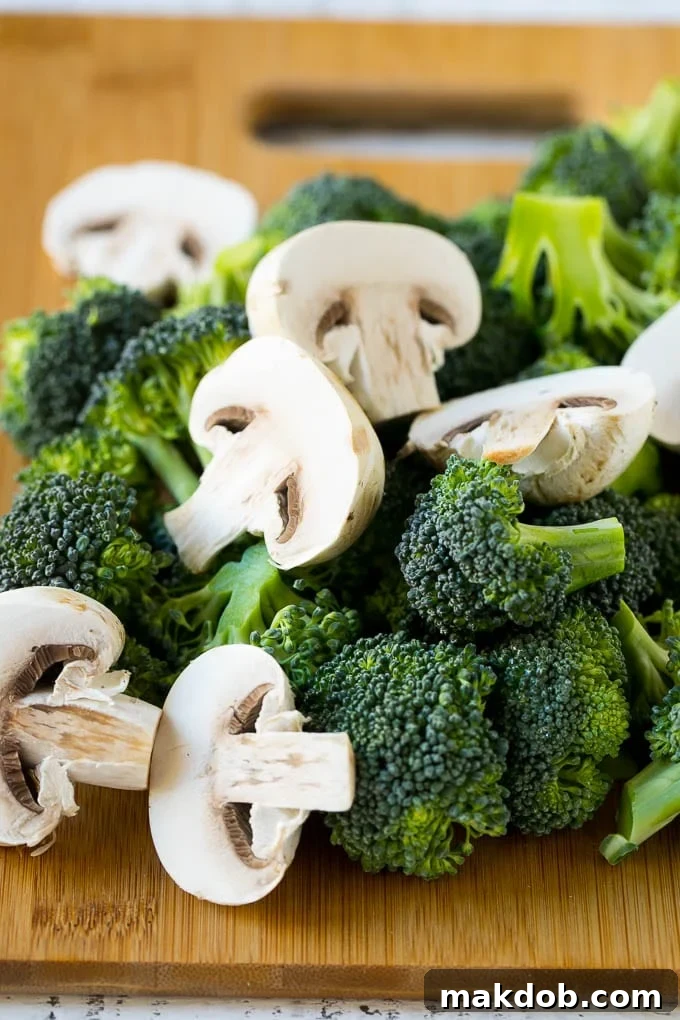 Chicken and Broccoli Stir Fry Recipe | Chicken Stir Fry | Healthy Chicken Recipe | Chicken and Broccoli | Chinese Food Broccoli florets and sliced mushrooms on a cutting board.