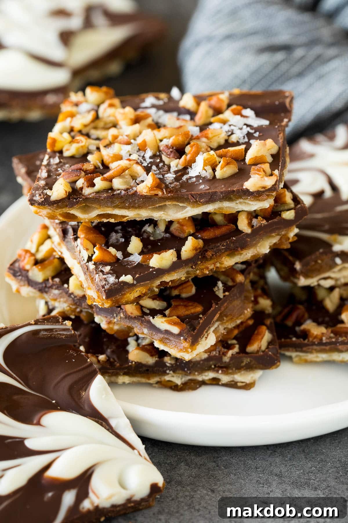 Matzo Toffee Brittle Bliss 6 A beautifully arranged stack of matzo crack squares, finished with chopped pecans and a sprinkle of coarse sea salt, showcasing its inviting texture.