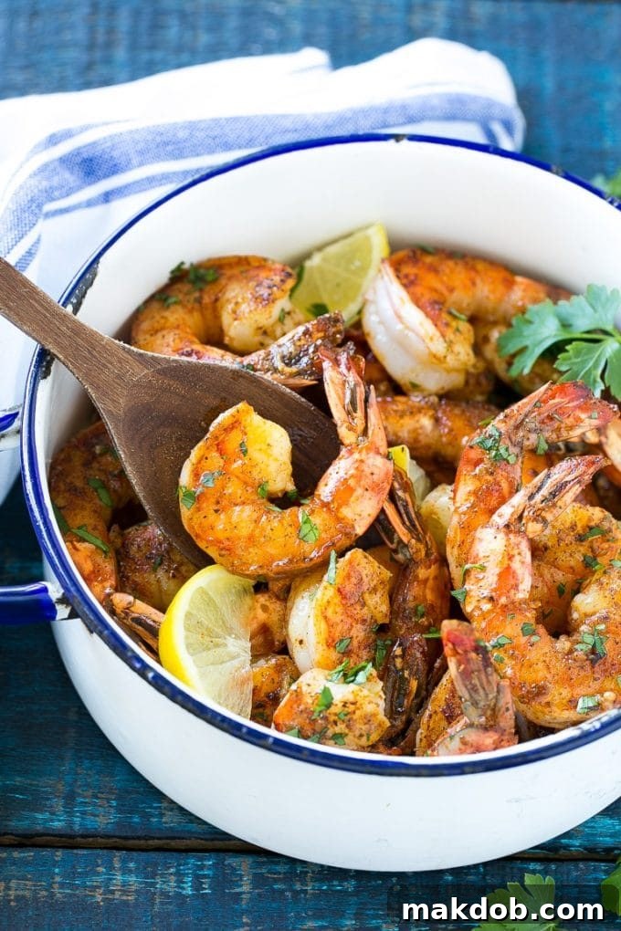 Delicious BBQ shrimp swimming in a rich, spiced butter sauce within a gleaming pot, ready to be devoured.