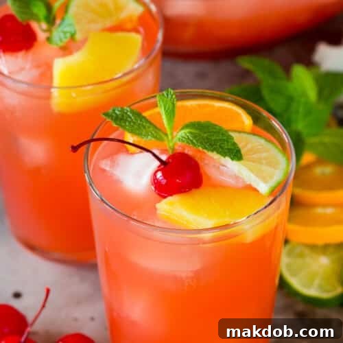 Cups of vodka punch topped with fruit and fresh mint.