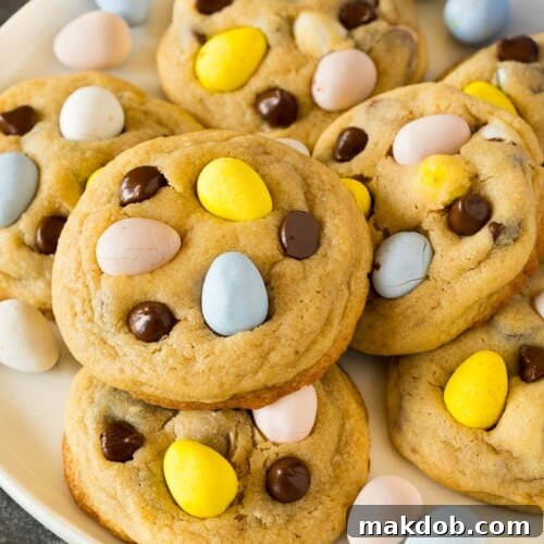 A plate of mini egg cookies topped with chocolate chips and chocolate eggs.