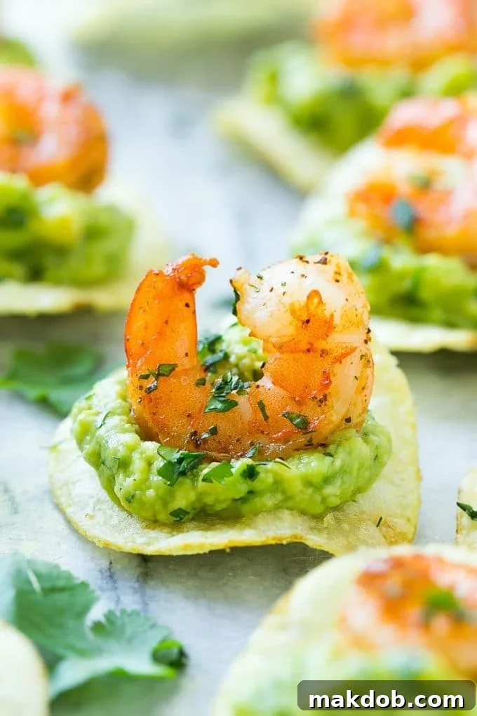 Close-up of Mexican shrimp bites, highlighting the vibrant guacamole, seasoned shrimp, and sturdy potato chip base.