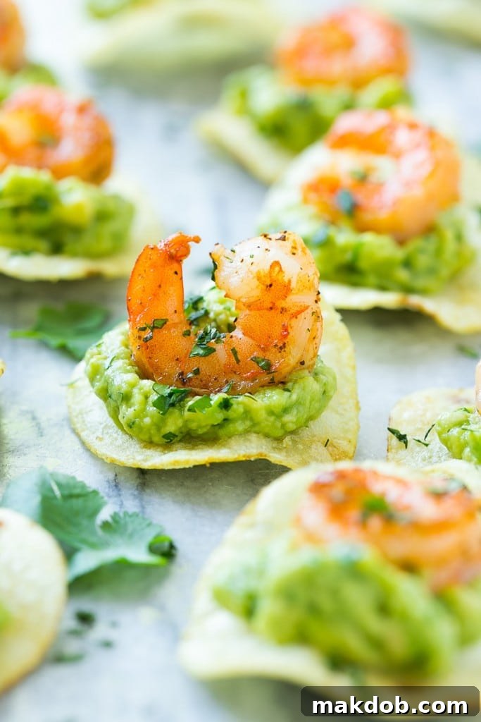 Platter of Mexican shrimp bites featuring perfectly spiced shrimp and guacamole on crispy potato chips.