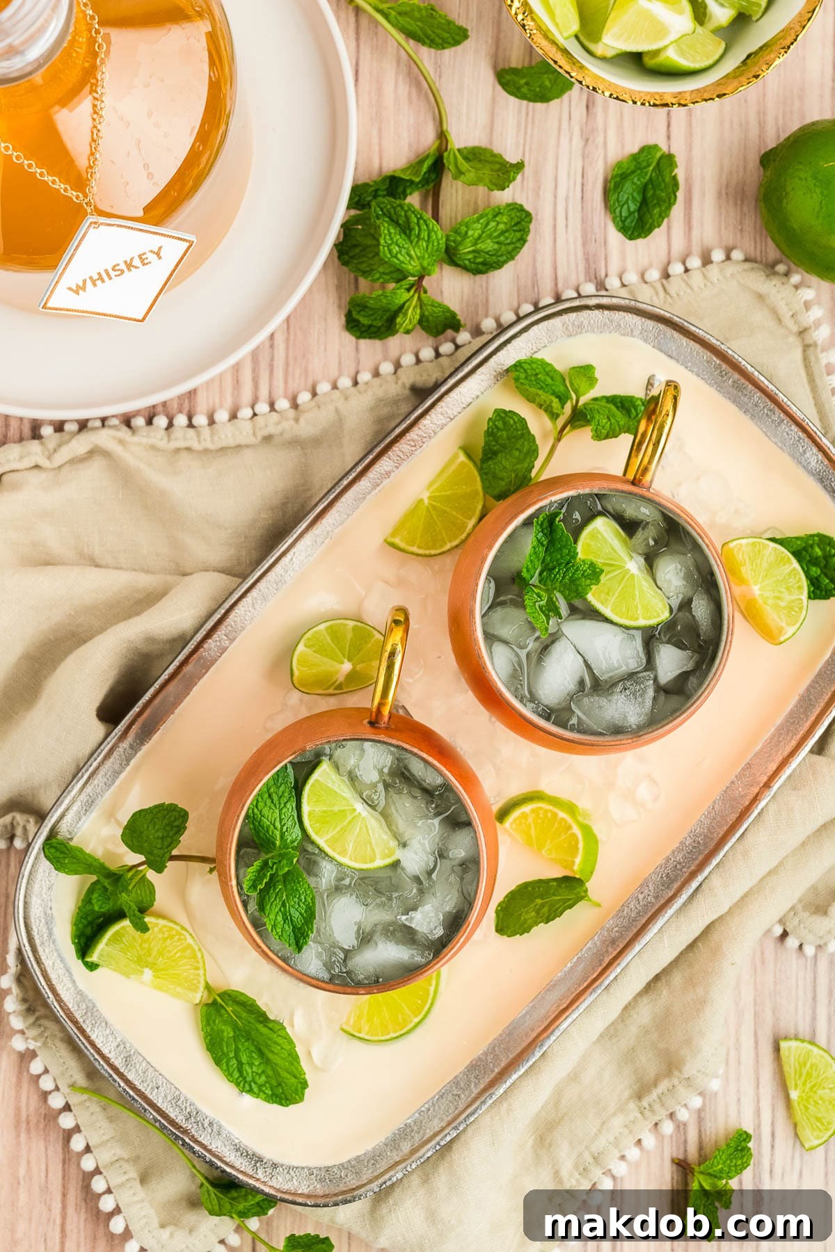 Refreshing Irish Mule 6 Two Irish mule drinks on a platter garnished with lime slices and fresh mint sprigs, ready to be served.