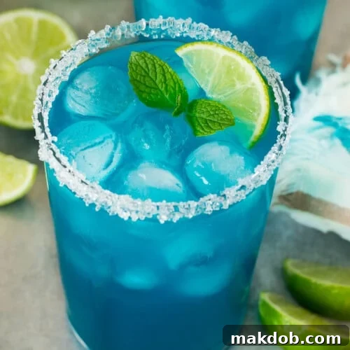 Electric Blue Margarita 7 Two cups of blue margarita with a sugared rim and lime wedge for garnish.