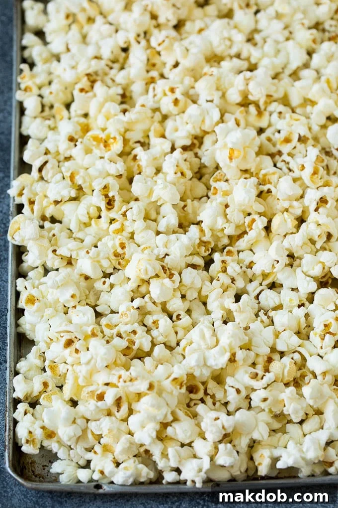 A sheet pan filled with freshly popped popcorn, ready for caramel coating.