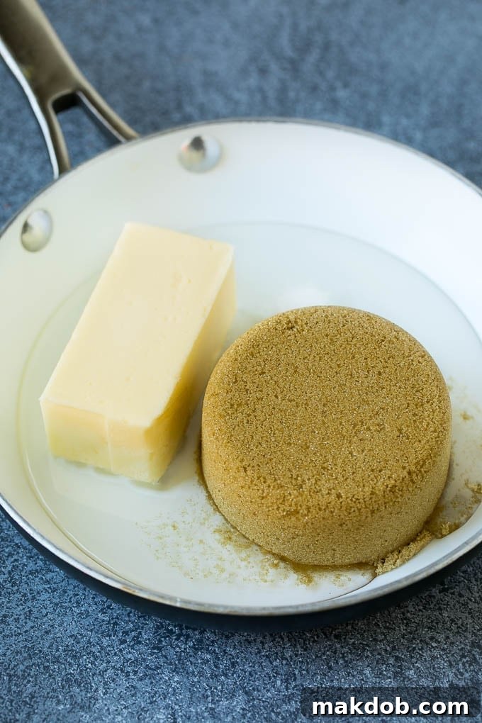 A saucepan on the stove containing brown sugar, butter, and corn syrup, beginning to melt.