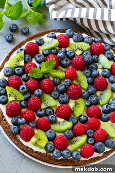 Sunshine Strawberry Lemon Cake 11 A vibrant brownie pizza generously topped with creamy cream cheese frosting and a colorful array of fresh fruit.