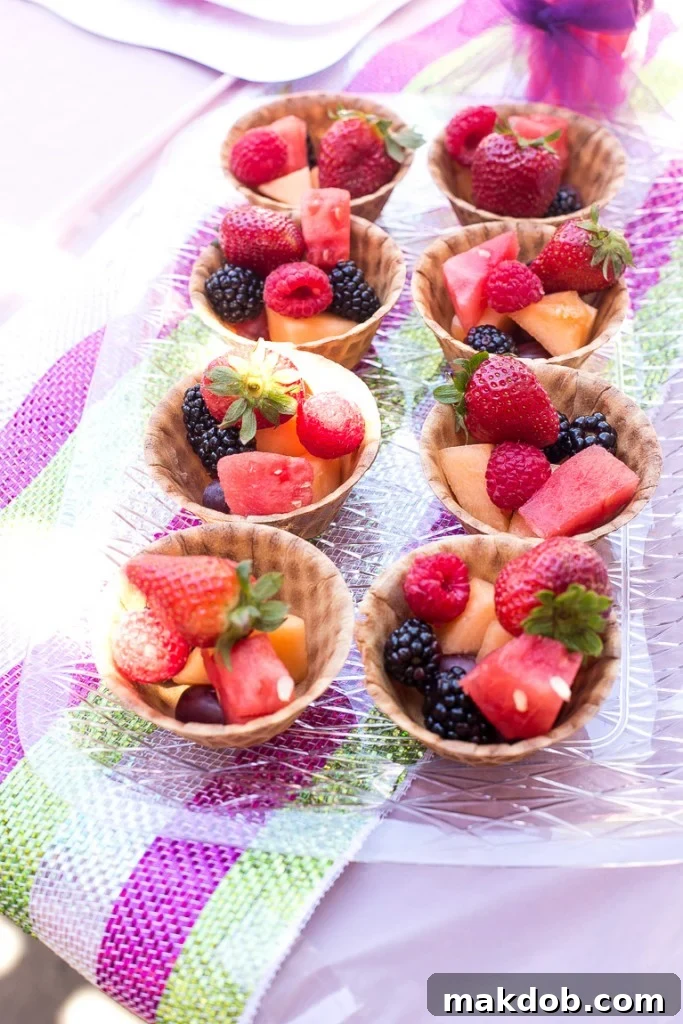 Delicious Fruit Salad in Mini Waffle Cone Bowls with Candy Spoons