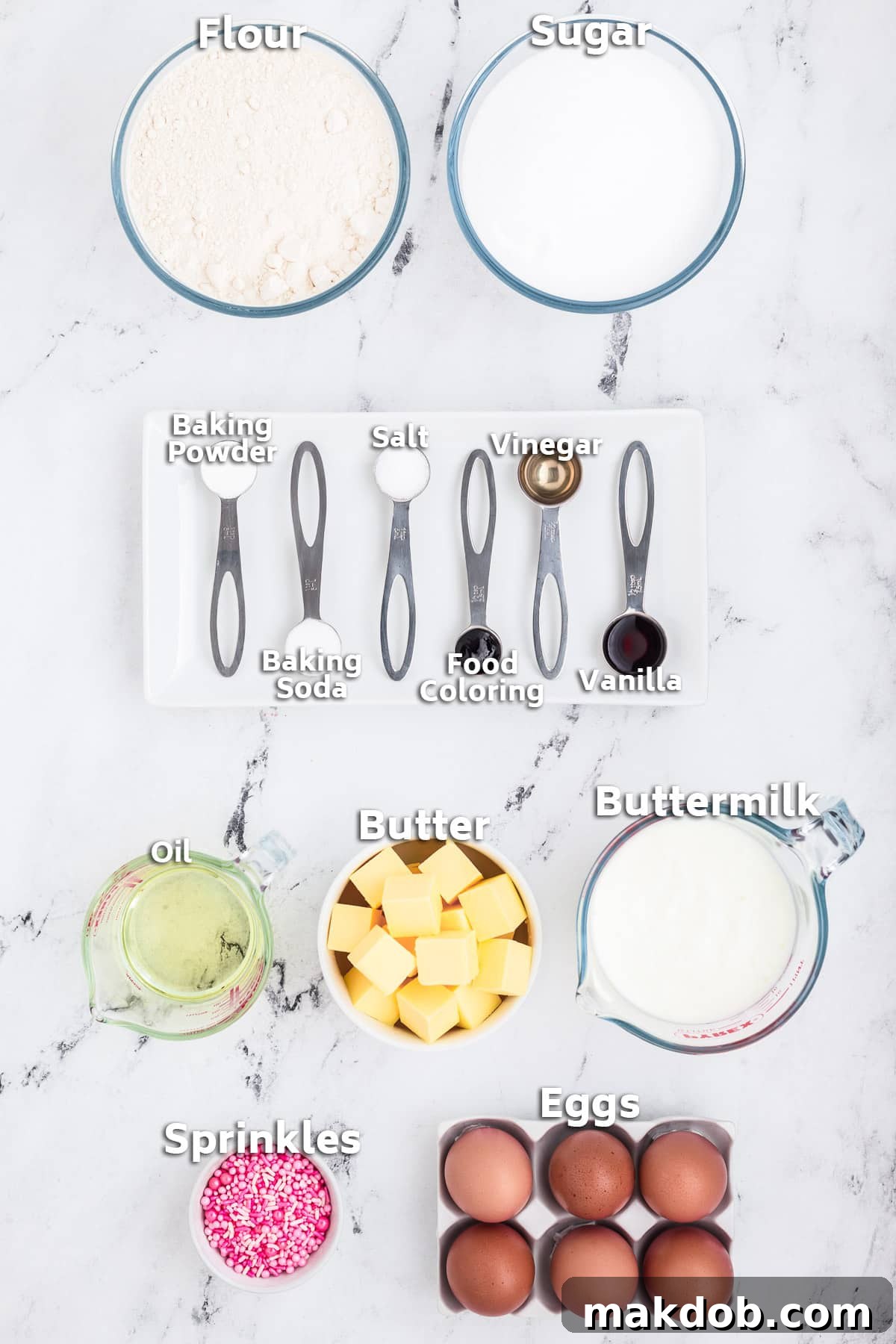 Various bowls holding ingredients like butter, oil, flour, sugar, eggs, and pink sprinkles, ready for Pink Velvet Cake preparation.