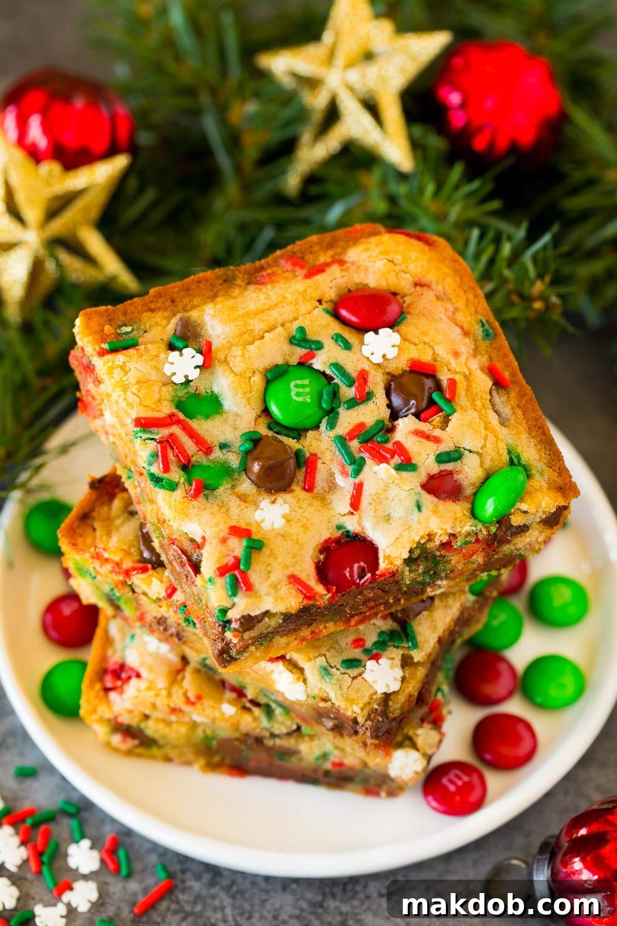 A beautifully arranged stack of freshly baked Christmas cookie bars on a festive plate, showcasing their rich texture and vibrant holiday toppings.