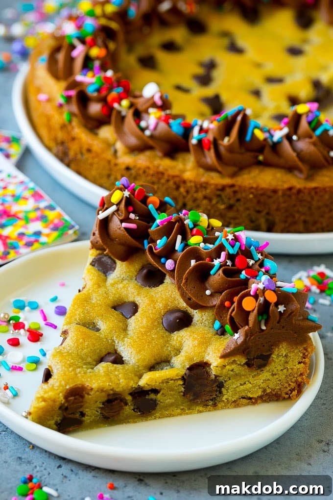 A Slice of Chocolate Chip Cookie Cake with Sprinkles A delightful slice of cookie cake, generously topped with chocolate frosting and vibrant sprinkles, ready to be enjoyed.