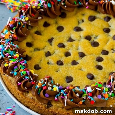 Festive Sprinkle Cookie Cake 2 A cookie cake topped with chocolate frosting and sprinkles.