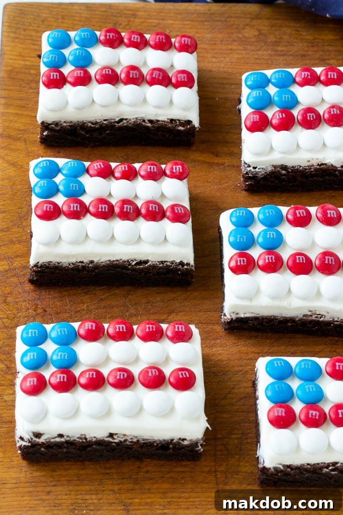 Delicious flag brownies decorated with white frosting and Red, White & Blue M&M's to create an American flag design.