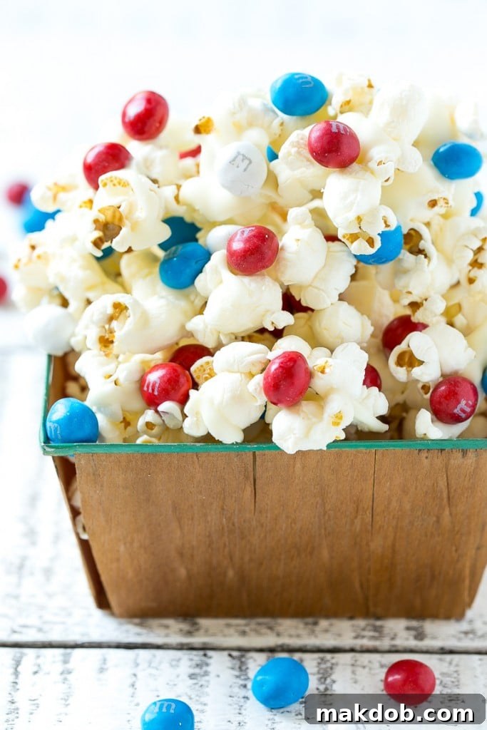 Delicious sweet and salty patriotic popcorn with white chocolate drizzle and Red, White & Blue M&M's.