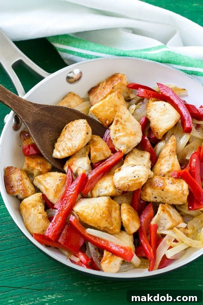 A skillet generously filled with perfectly seared chicken, caramelized onions, and tender bell peppers.
