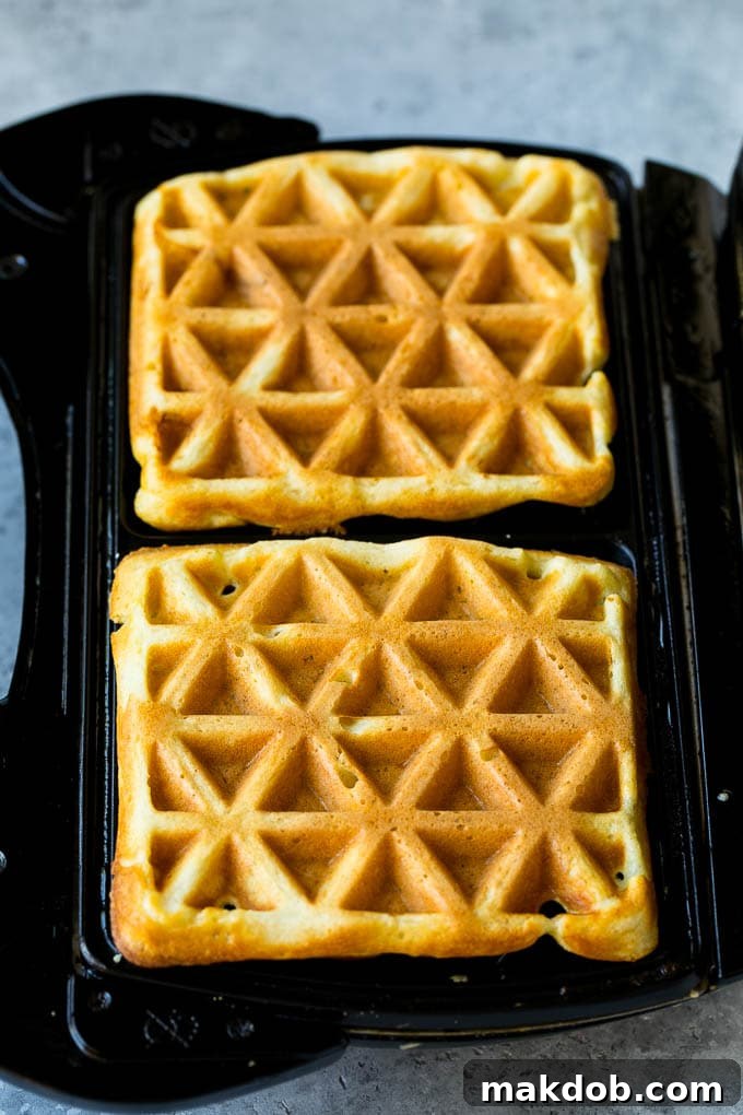 Waffles inside of a waffle iron.