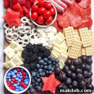 An image of a charcuterie board with berries, cheeses, and meats.