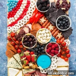 An image of a charcuterie board with cheeses, chips, fruits and veggies.