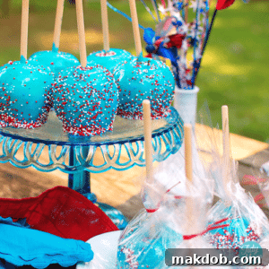 A group of classic blue candy coated apples, adorned with festive red and white sprinkles.